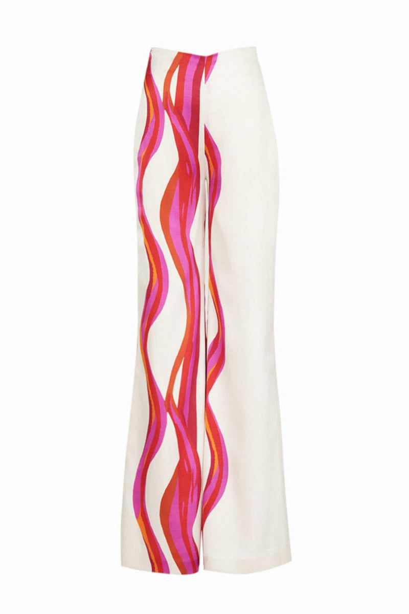 Woman in ivory satin pant set with pink and orange wave print