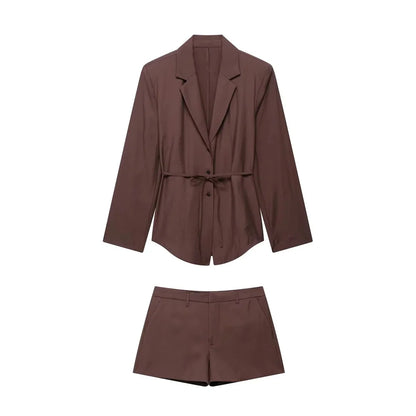 Woman in brown satin blazer dress with belt and black handbag