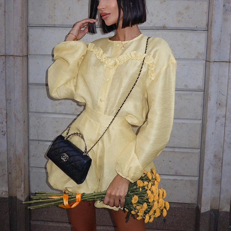 Woman in yellow linen romper with black quilted handbag
