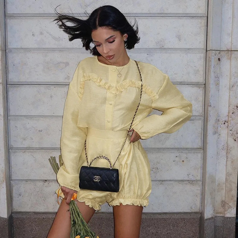Woman in yellow linen romper with black quilted handbag