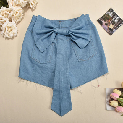 Back view of light wash denim shorts with large bow detail