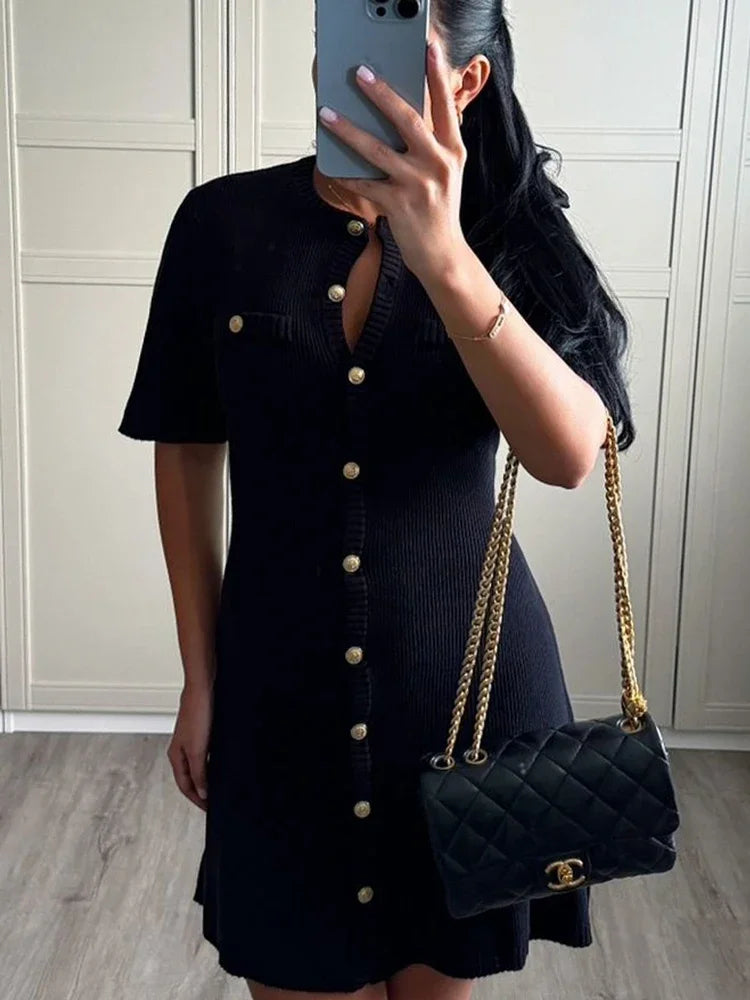 Woman in ivory boucle knit dress with brown handbag