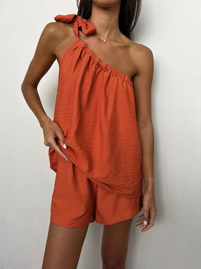 Woman wearing a rust-colored one-shoulder top and shorts set
