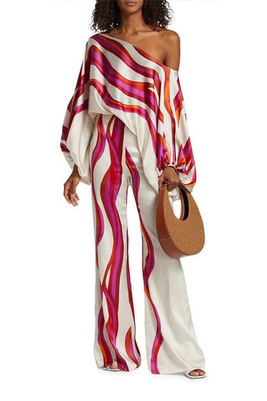 Woman in ivory satin pant set with pink and orange wave print
