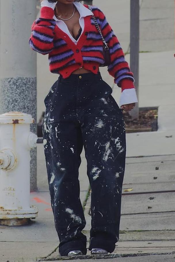 Woman wearing red and lavender striped fuzzy cardigan with paint-splattered jeans.