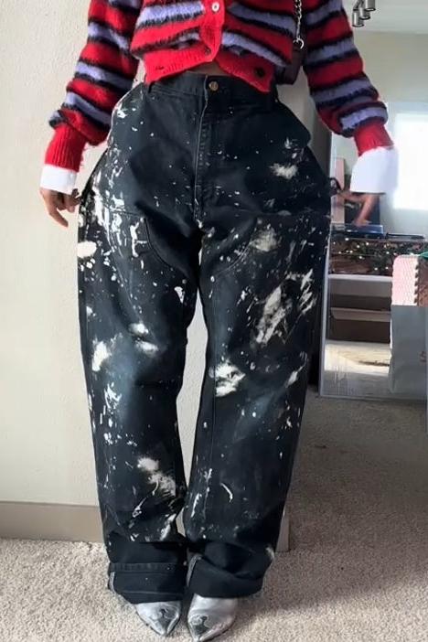Woman wearing red and lavender striped fuzzy cardigan with paint-splattered jeans.