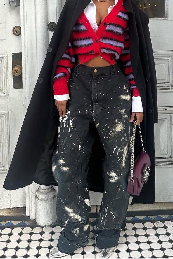 Woman wearing red and lavender striped fuzzy cardigan with paint-splattered jeans.