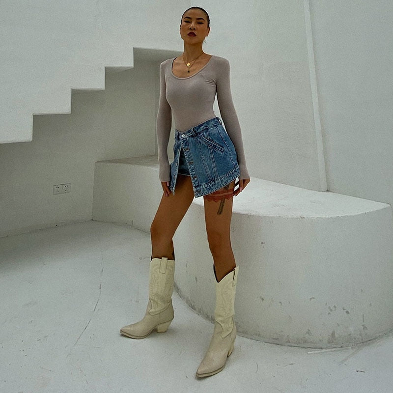Woman wearing light wash denim skort with button detail