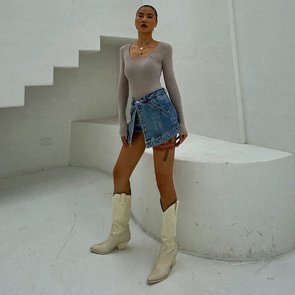 Woman wearing light wash denim skort with button detail