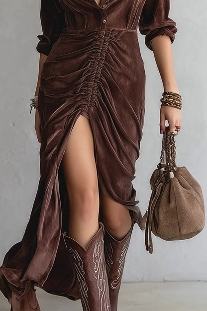 Woman in brown velvet midi dress with cowboy boots and a brown bag