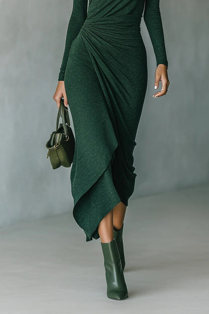 Woman in forest green ribbed turtleneck midi dress with draped skirt and matching boots
