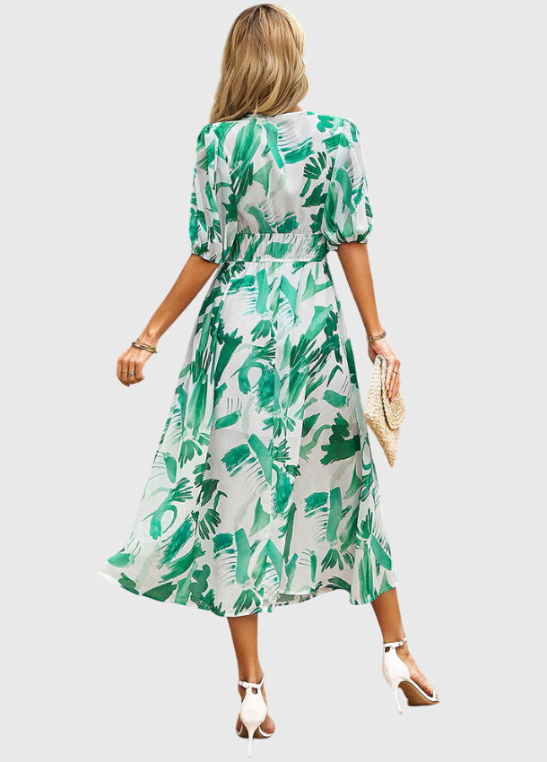 Blue - A woman wearing a vibrant multi-color abstract floral print chiffon midi dress with puff sleeves, a V-neckline, and a smocked waist, paired with white heeled sandals.