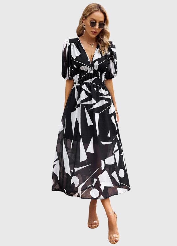 Black - A woman wearing a vibrant multi-color abstract floral print chiffon midi dress with puff sleeves, a V-neckline, and a smocked waist, paired with white heeled sandals.