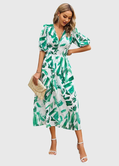 Blue - A woman wearing a vibrant multi-color abstract floral print chiffon midi dress with puff sleeves, a V-neckline, and a smocked waist, paired with white heeled sandals.