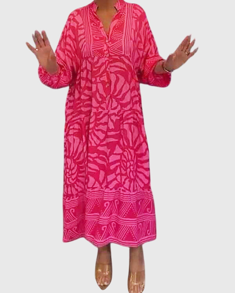 Pink - A woman wearing a vibrant pink and light pink abstract floral print maxi dress with long sleeves, a split V-neckline, and a tiered skirt featuring geometric border patterns.