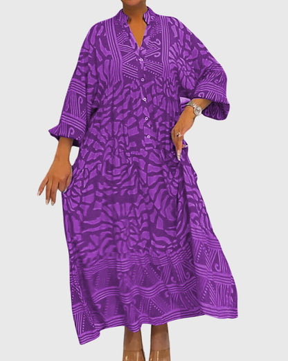 Purple - A woman wearing a vibrant pink and light pink abstract floral print maxi dress with long sleeves, a split V-neckline, and a tiered skirt featuring geometric border patterns.