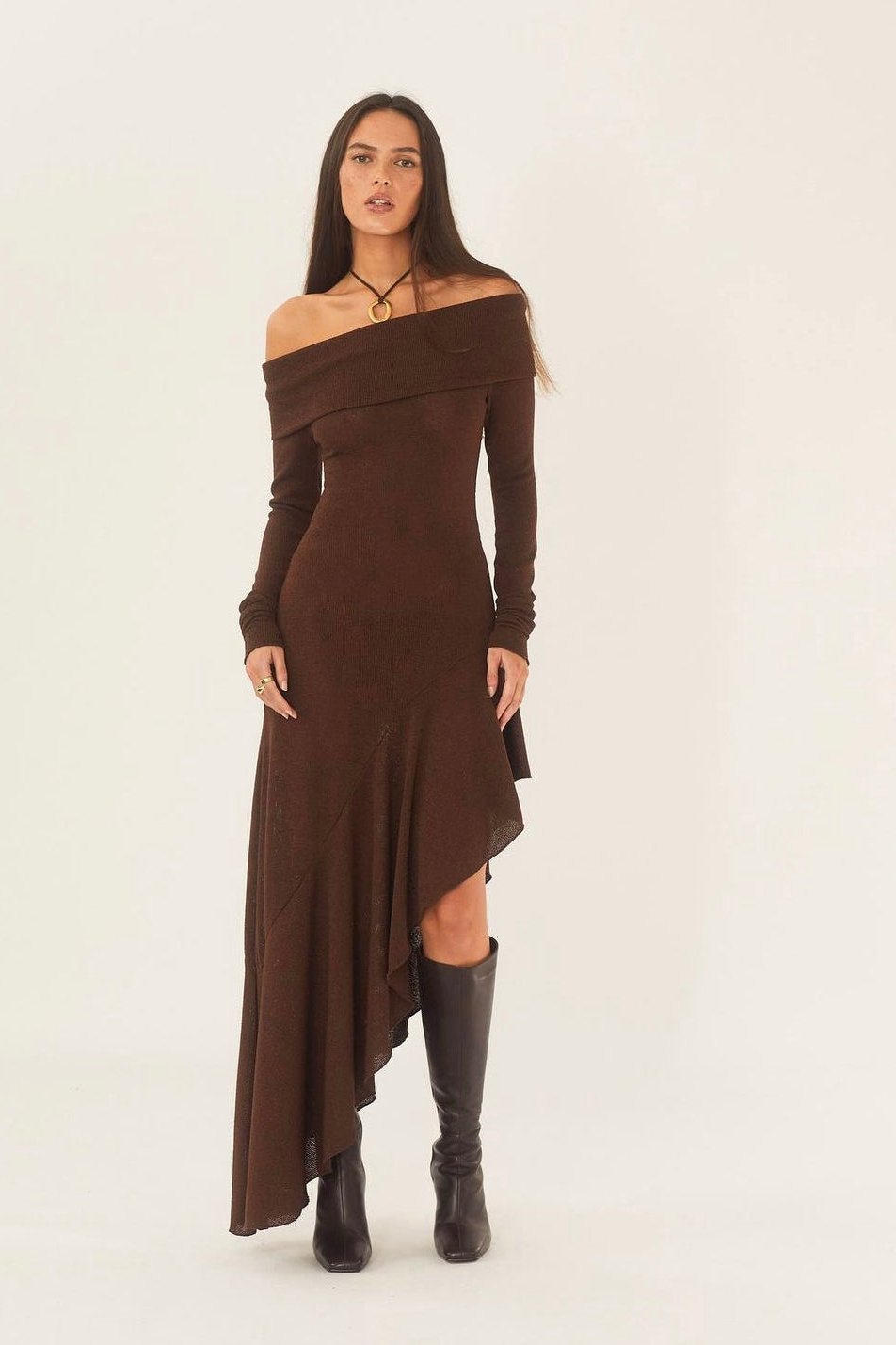 Woman in brown off-the-shoulder ribbed knit dress and black heeled boots