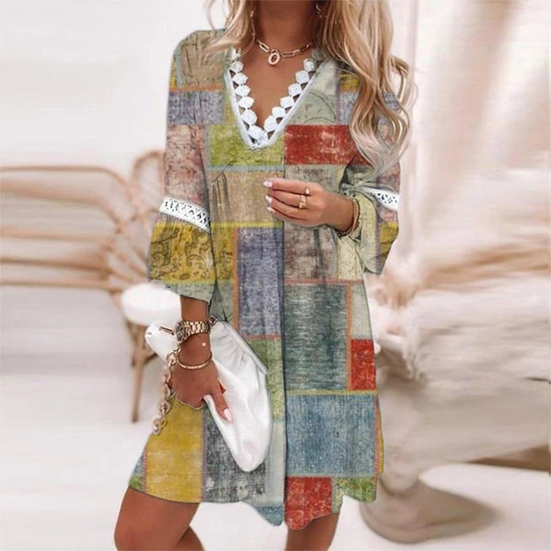 Yellow - A woman wearing a white mini sundress with a blue Mediterranean botanical print, featuring a V-neckline with white crochet lace trim and 3/4 bell sleeves with lace inserts.