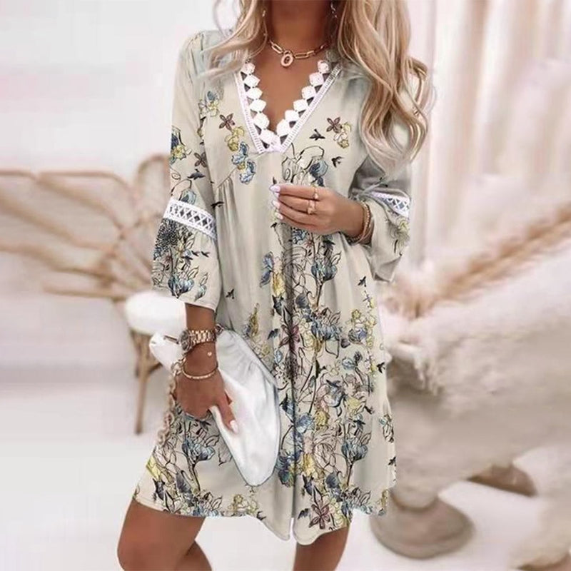 Light Grey - A woman wearing a white mini sundress with a blue Mediterranean botanical print, featuring a V-neckline with white crochet lace trim and 3/4 bell sleeves with lace inserts.