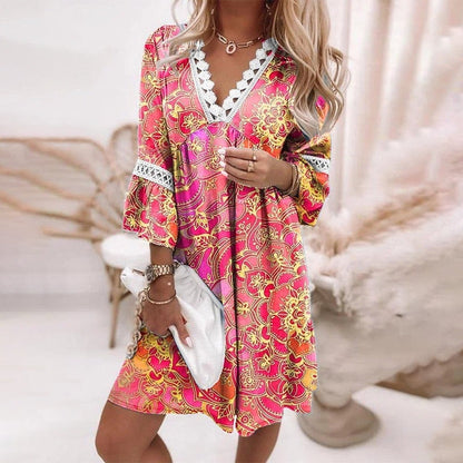 Pink - A woman wearing a white mini sundress with a blue Mediterranean botanical print, featuring a V-neckline with white crochet lace trim and 3/4 bell sleeves with lace inserts.