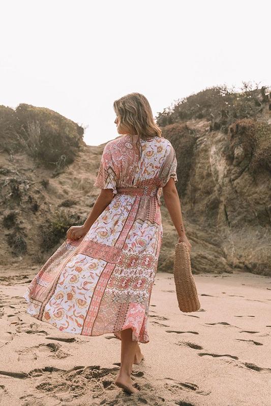 Woman in peach floral maxi dress on beach