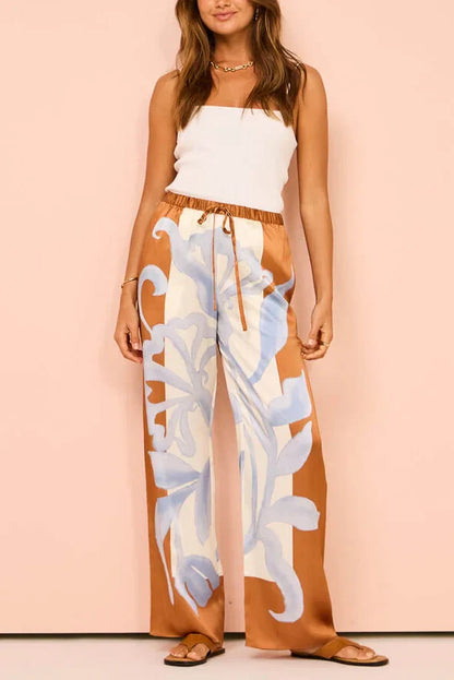 Woman in ivory, brown, and blue floral satin pajama set