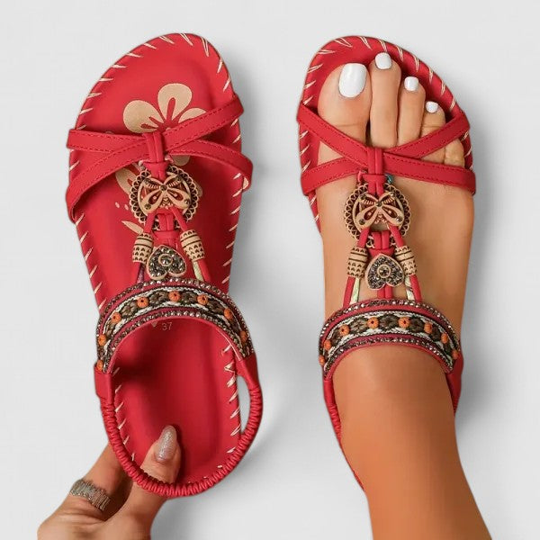 Toledo Red - Faux-leather flat slingback sandals featuring a beaded medallion centerpiece, embroidered instep strap, and contrast stitching along the sole edge.