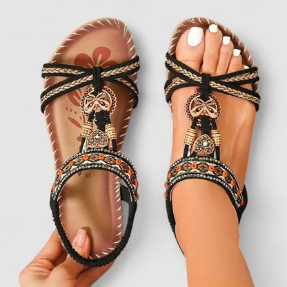 Light Black - Faux-leather flat slingback sandals featuring a beaded medallion centerpiece, embroidered instep strap, and contrast stitching along the sole edge.