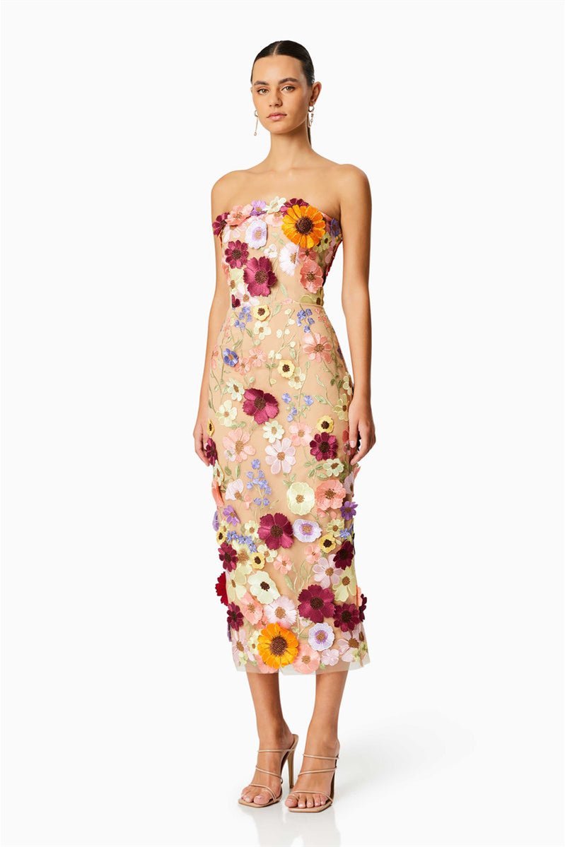 Woman in strapless tulle midi dress with colorful floral appliqués