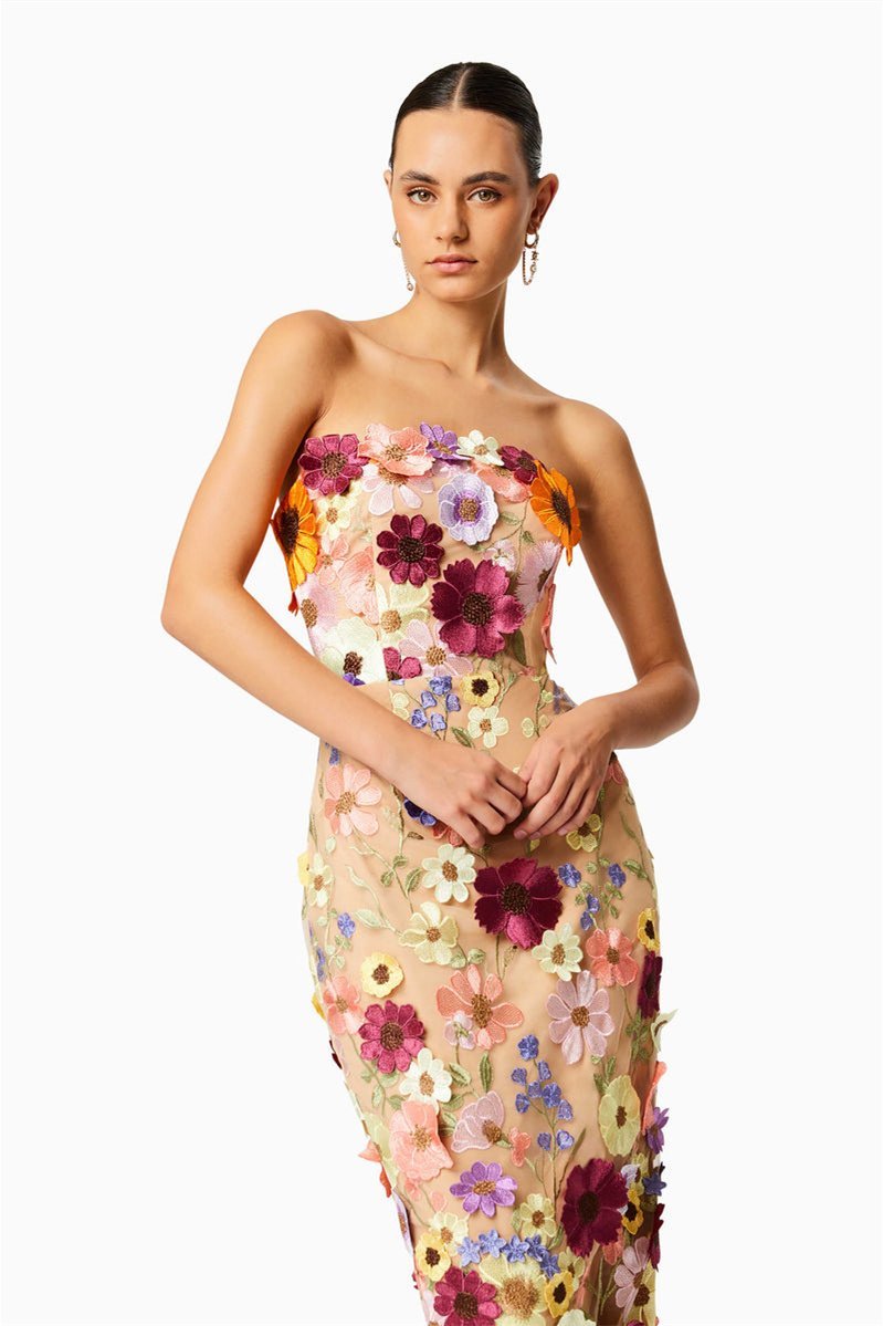 Woman in strapless tulle midi dress with colorful floral appliqués