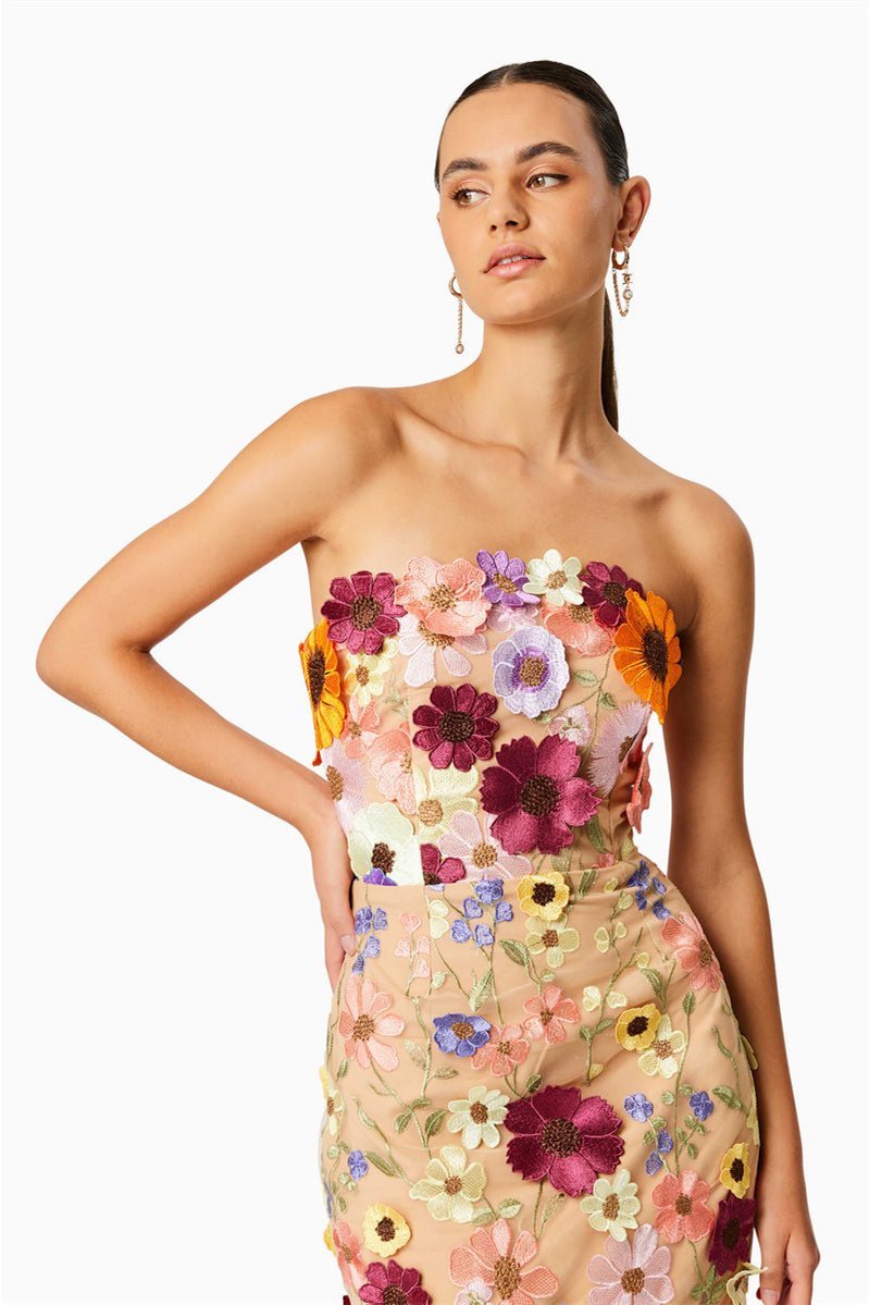 Woman in strapless tulle midi dress with colorful floral appliqués