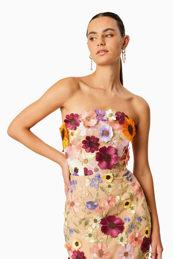 Woman in strapless tulle midi dress with colorful floral appliqués