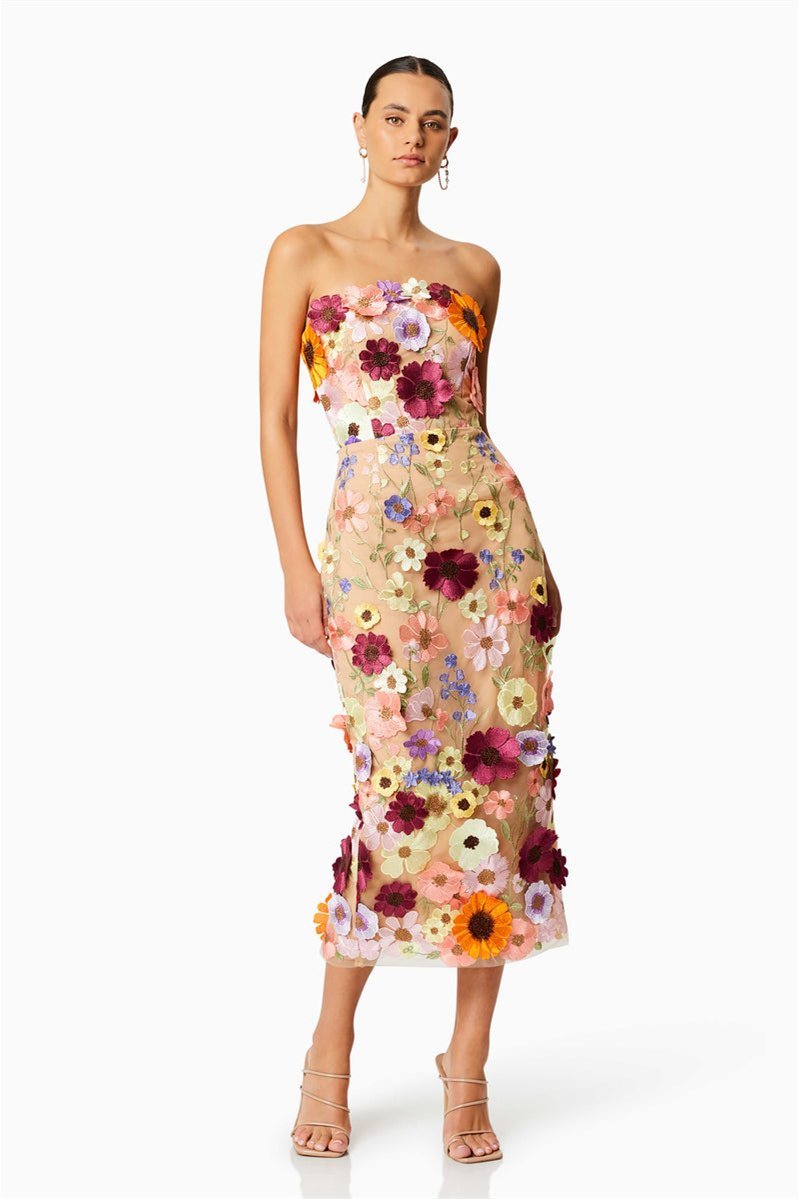 Woman in strapless tulle midi dress with colorful floral appliqués