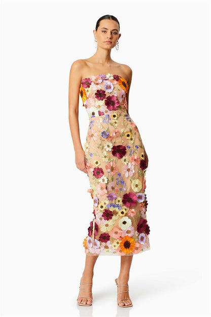 Woman in strapless tulle midi dress with colorful floral appliqués