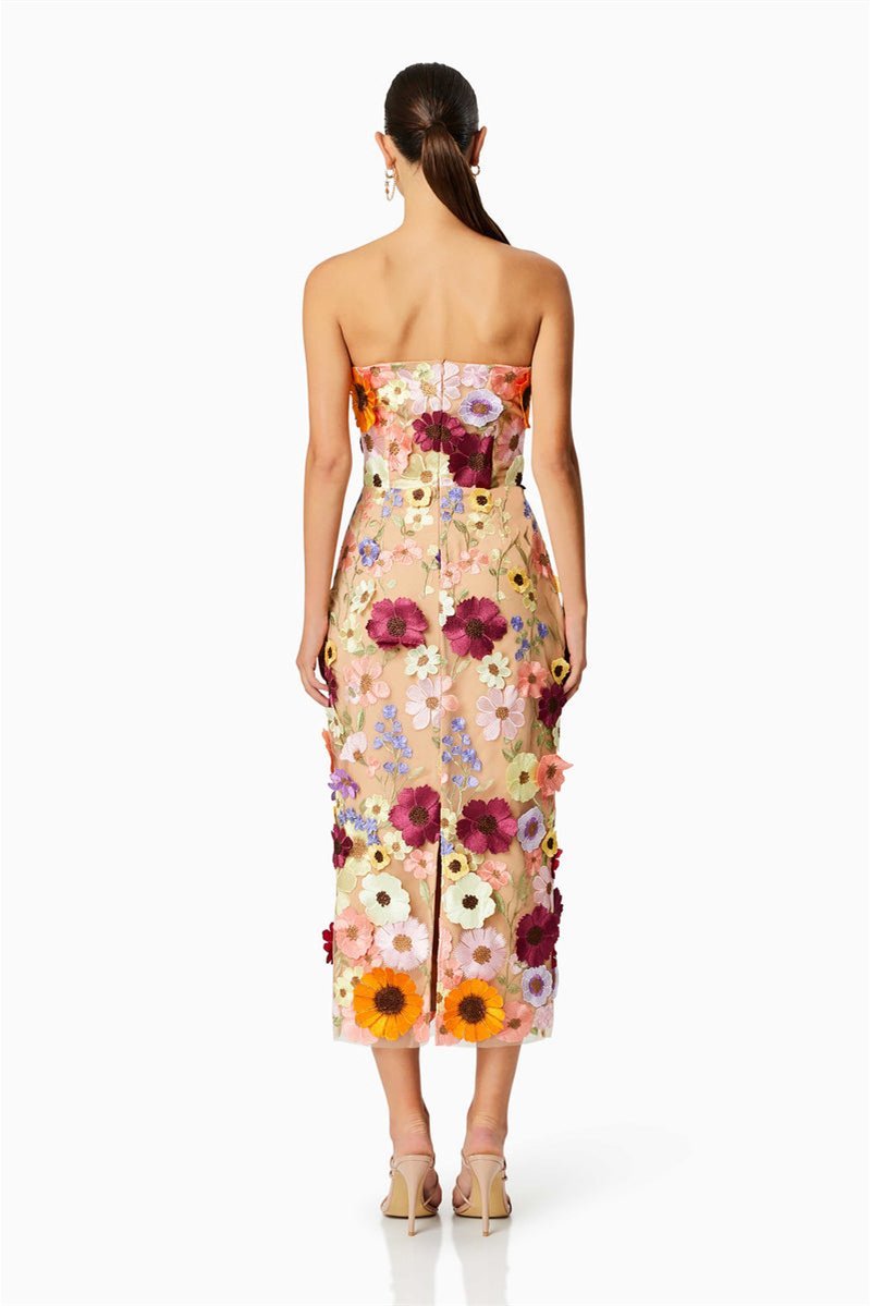 Woman in strapless tulle midi dress with colorful floral appliqués