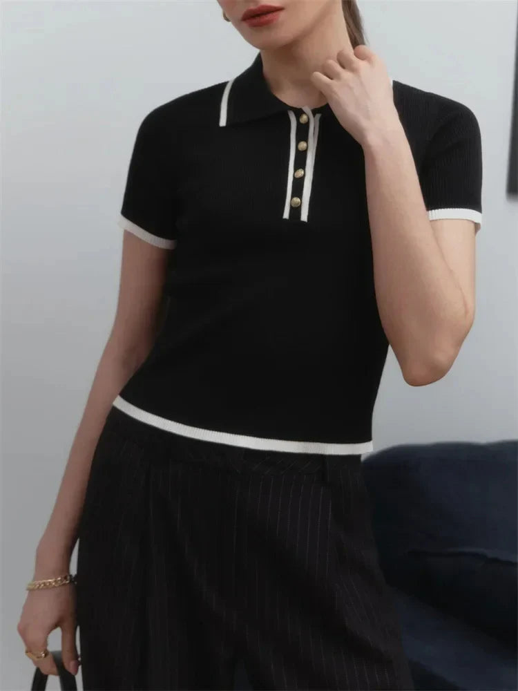 Woman wearing white ribbed knit polo shirt with brown belt and beige trousers