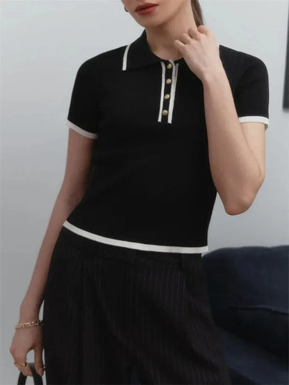 Woman wearing white ribbed knit polo shirt with brown belt and beige trousers