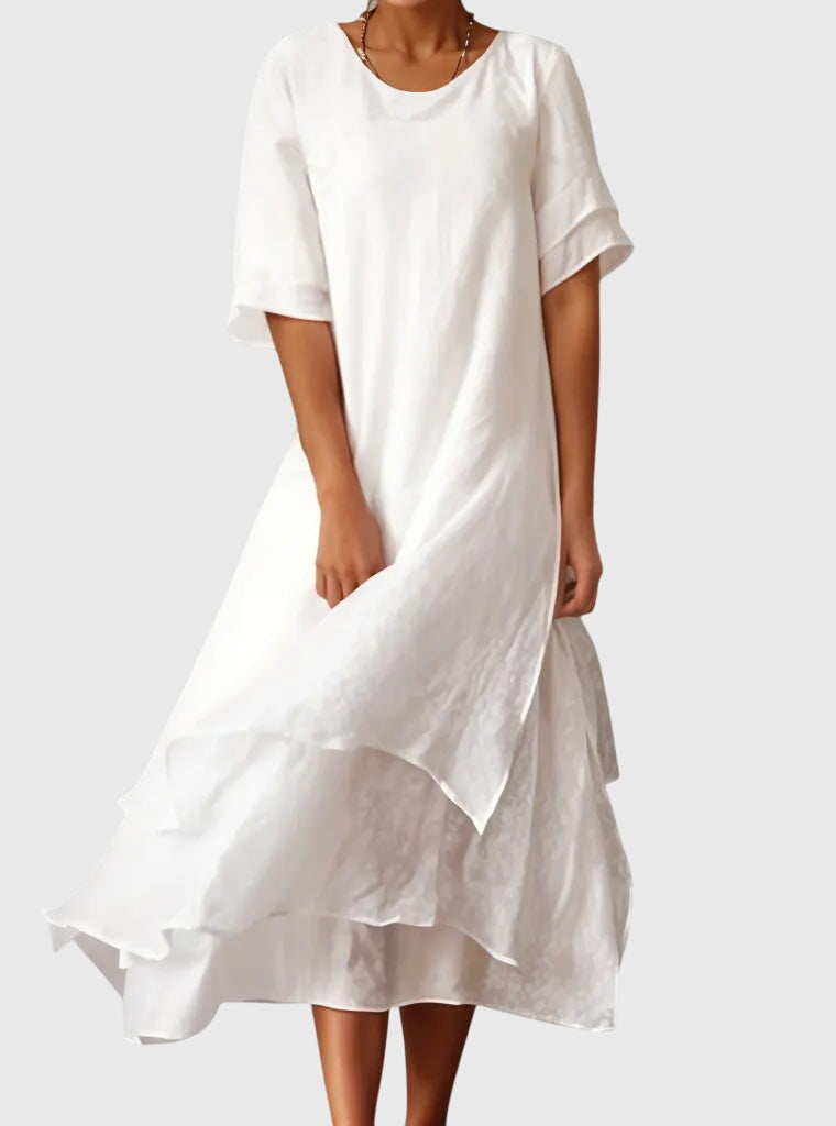 White - A woman wearing a light pink, double-layered chiffon midi dress with short sleeves, a scoop neck, and a flowy asymmetric hemline.