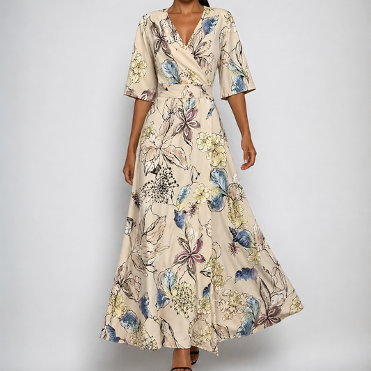 Beige - A woman wearing a cream-colored maxi dress featuring a multi-colored botanical floral print, structured V-neckline, elbow-length sleeves, and a flowing A-line skirt.
