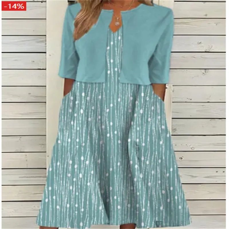 Green Blue - A woman wearing a dusty blue mock-layered midi dress featuring a solid 3/4-sleeve bodice, a split neckline, and a flowy skirt with a white botanical branch print.