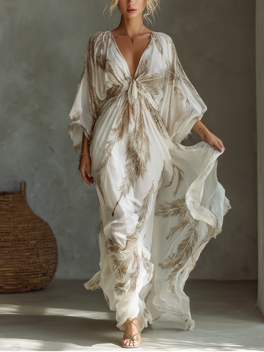 Ivory - Woman wearing a flowing botanical print v-neck maxi dress with wide sleeves, walking to show the fluid drape of the lightweight fabric