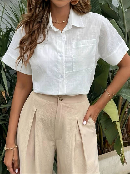 Woman wearing white linen short-sleeve shirt and beige pleated trousers