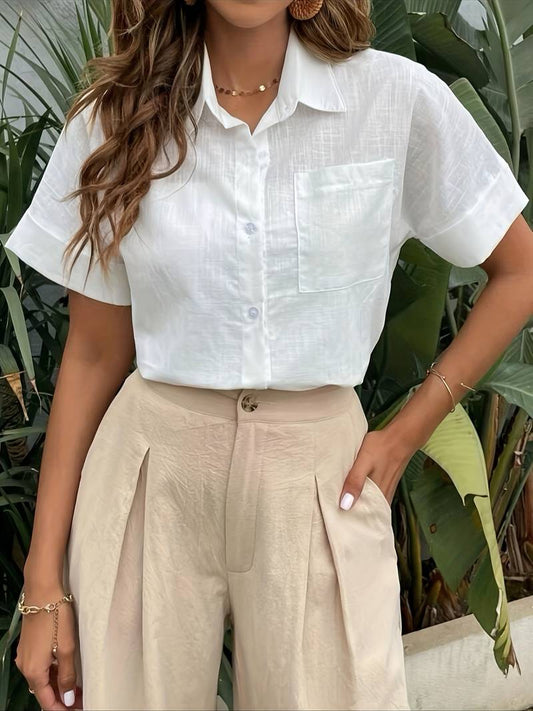Woman wearing white linen short-sleeve shirt and beige pleated trousers