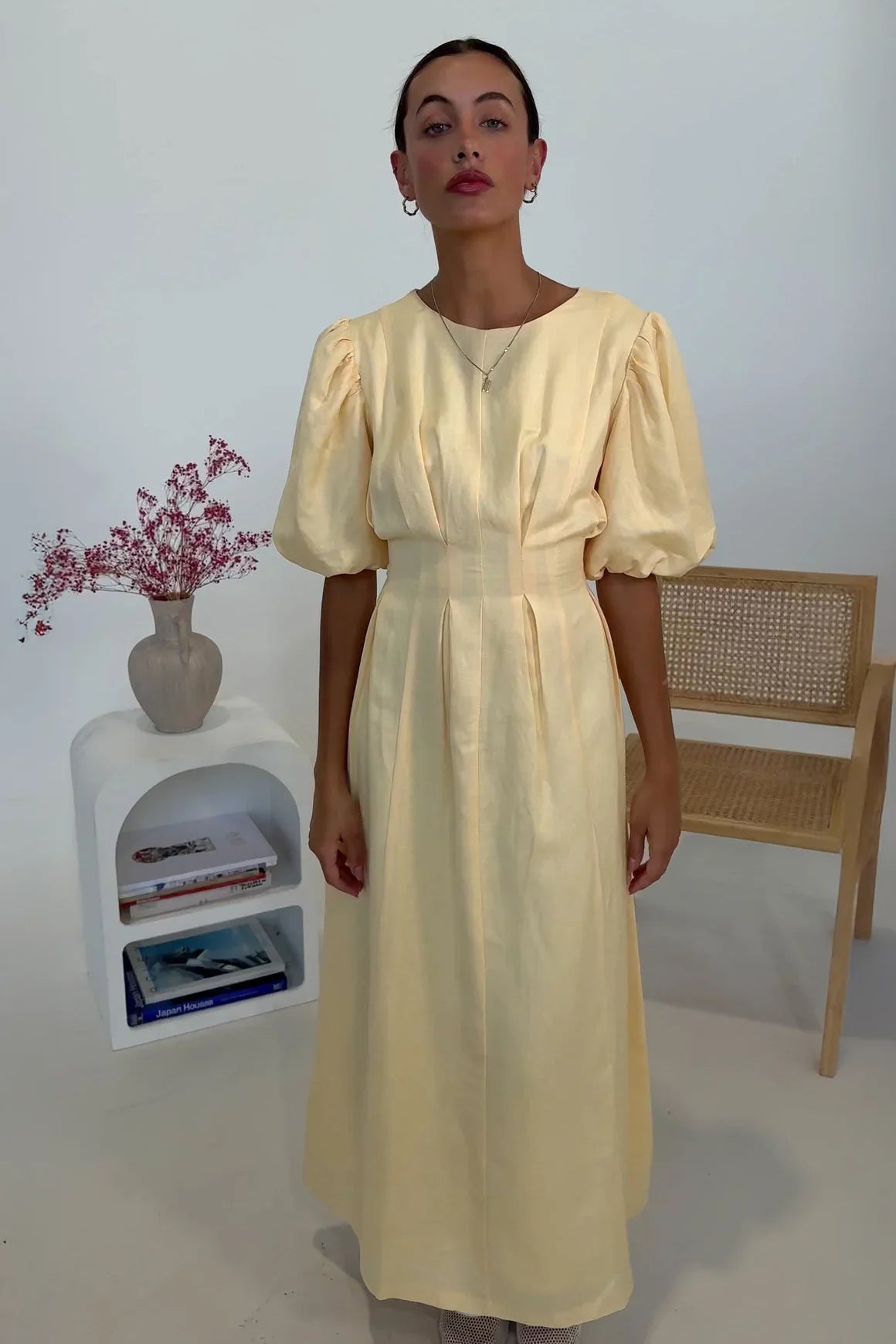 Woman in pale yellow linen maxi dress with puff sleeves