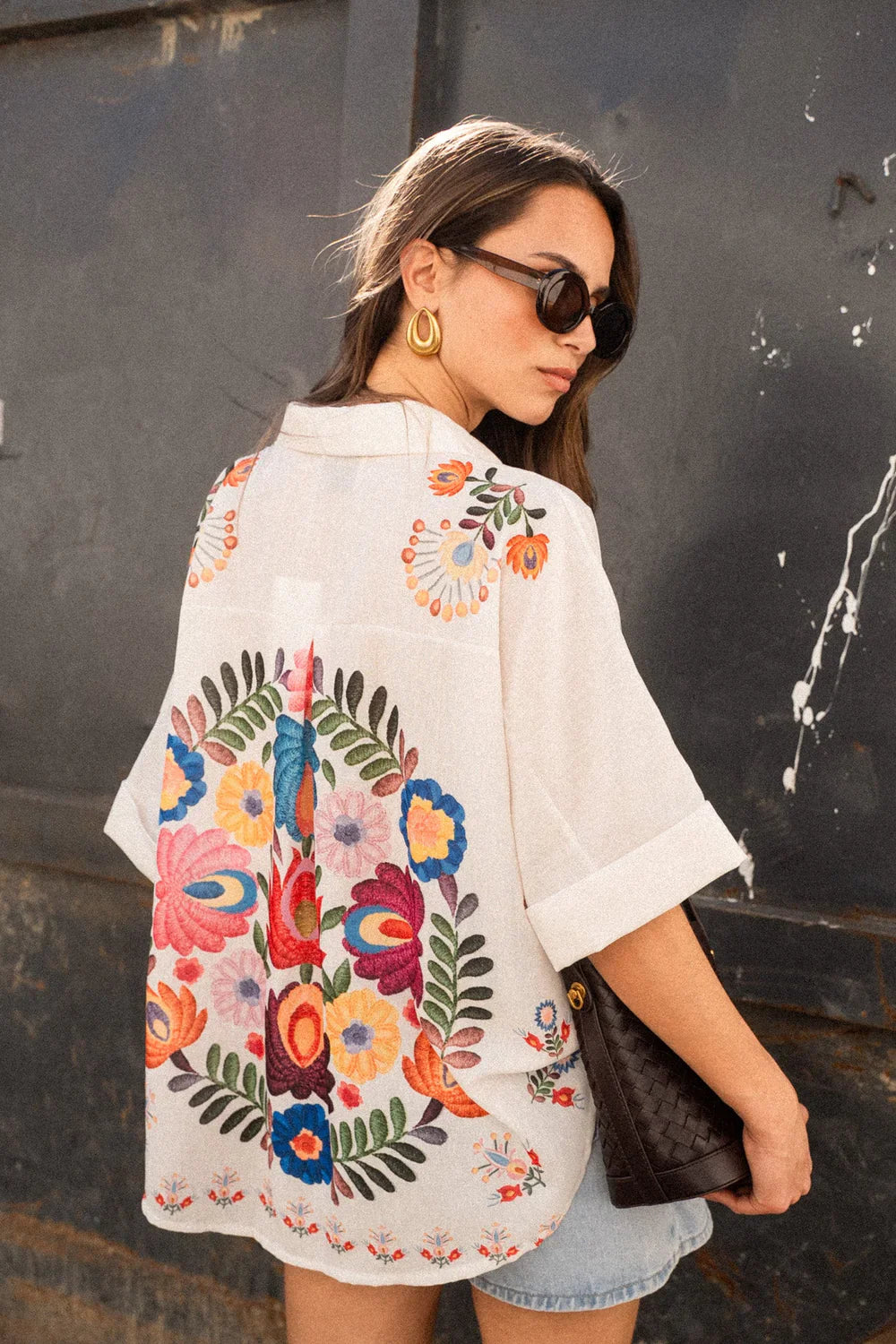 Woman in white linen shirt with colorful floral embroidery