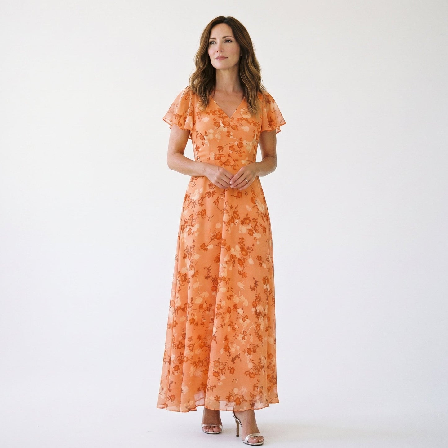 Orange - Model wearing a floral flutter-sleeve maxi dress with a V-neckline and flowy silhouette.