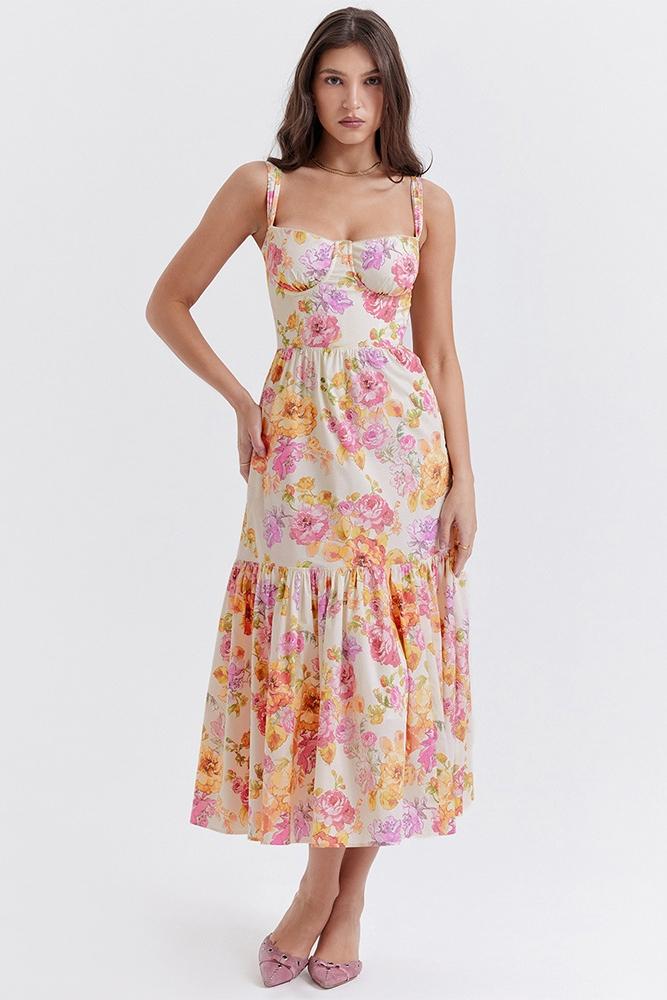 Woman in floral print sundress leaning on stone wall