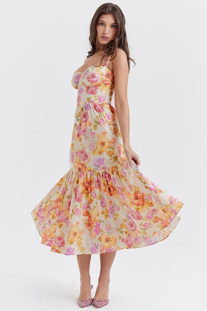 Woman in floral print sundress leaning on stone wall