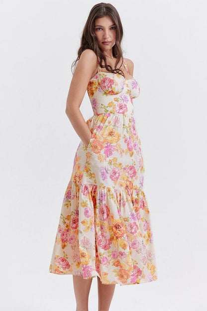 Woman in floral print sundress leaning on stone wall