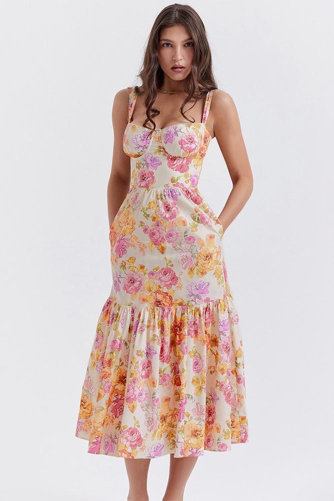 Woman in floral print sundress leaning on stone wall